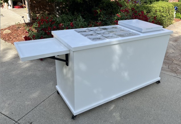 Frozen treats cart with the freezer lid closed and fold-out trays extended