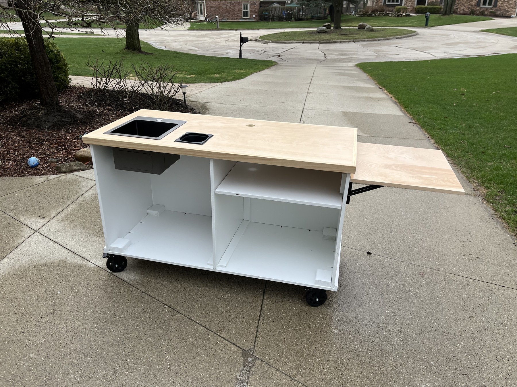 Coffee cart with a natural wood top, drop-in wells, a fold-out wood side shelf and open storage below