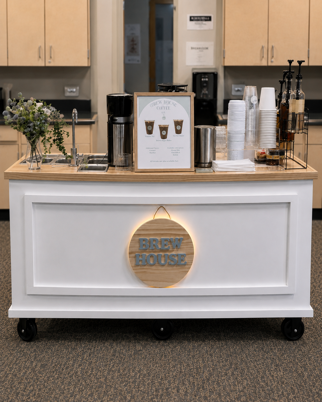 Brew House Coffee Co. cart: a white cart with a wood top and a round BREW HOUSE sign on the panel front, set up as a coffee station indoors
